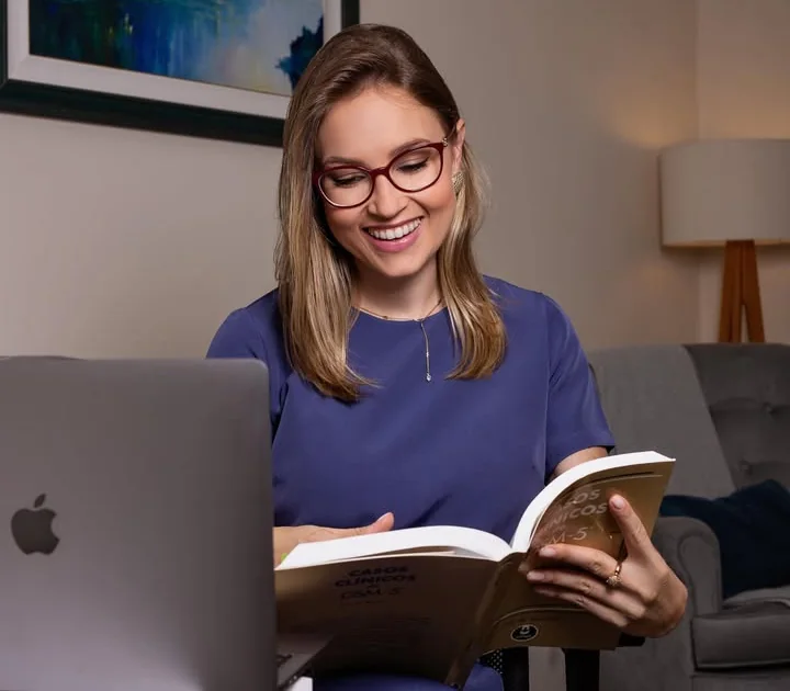 Aline Sá Copetti lendo um livro de casos clínicos no consultório